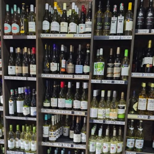 Bottles of alcohol placed in a shelf at a liquor store