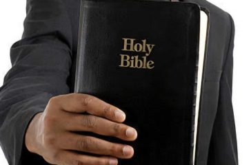 A pastor carrying bible, black in colour